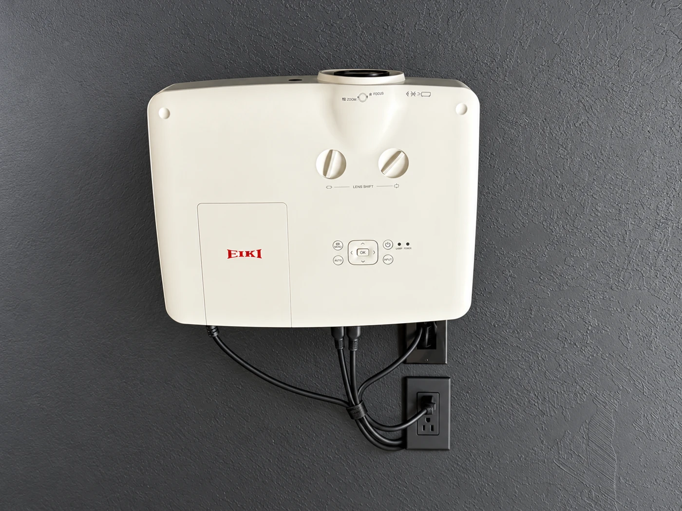 White EIKI projector mounted on the dark wall